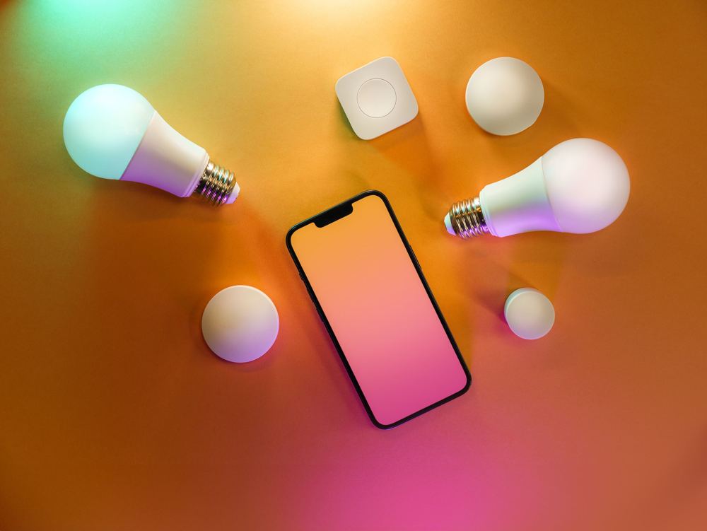 Lâmpadas inteligentes coloridas ao lado de celular