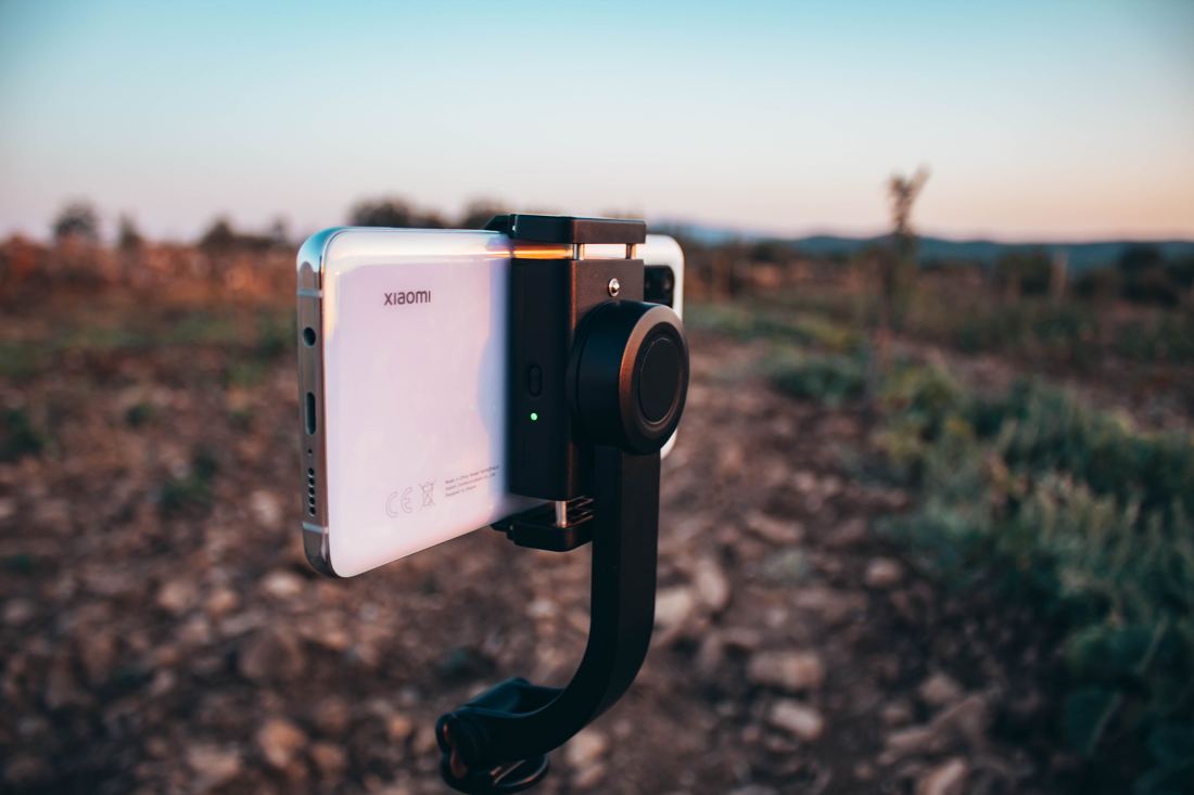 Smartphone Xiaomi montado em estabilizador (gimbal), fotografado ao ar livre